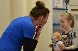 Medical assisting student and child with teddy bear